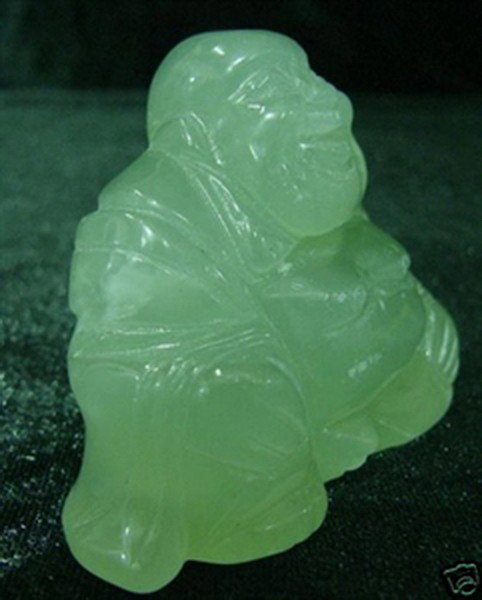 JADE SITTING BUDDHA: This Buddha is made from one solid piece of Southern Jade. High transparent. Light green with some spots dark green. Very detailed carving