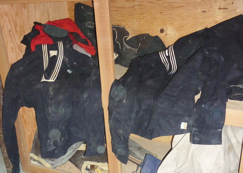 U.S Navy Uniforms: Lot of WWII U.S Navy uniforms and equipment, including: (3) uniforms, heavy over coat, extra buttons, bedding, bag and etc.