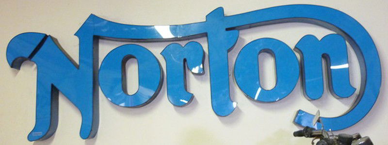 Norton Motorcycle Interior Dealer Sign: (1) 3'2" x 8'6". Blue raised Norton lettering with black sides. Minor crack to the N in Norton.