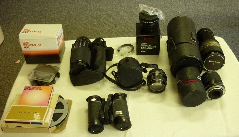 Camera Lenses and Film: (Lot) Including: Pentax-M lenses, Vivitar Series 1 70-210mm, Soligor 95-210mm, SMC Pentax-M binoculars and etc.