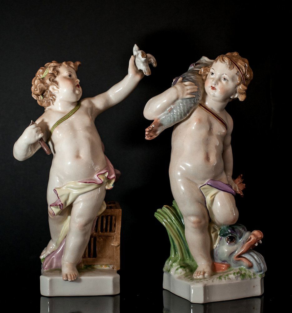 KPM Porcelain Figurines: (2) Total. 8"h. Including: (1) cherubim with torch and dove resting by birdcage, damage to torch and (1) boy holding fish and resting on another fish. Shipping: USPS or Fedex. $50.00. We will ship int