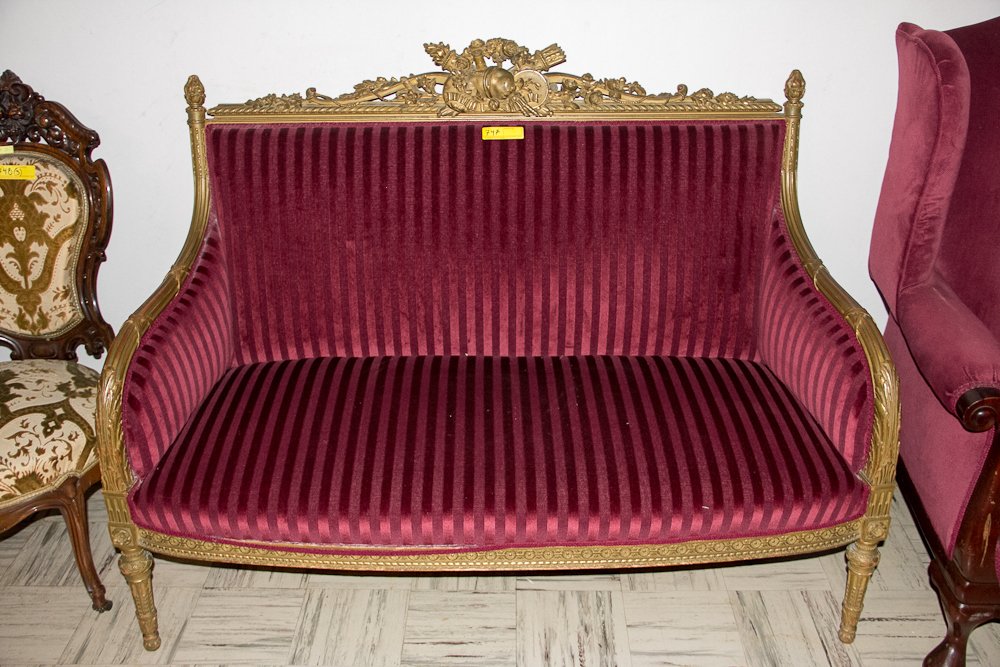French Settee: (1) Wood frame with green painted finish. Carved floral and wheat center finial with striped red upholstery. Shipping: Pickup only. Neale and Sons will not ship this item. The buyer is responsible to 