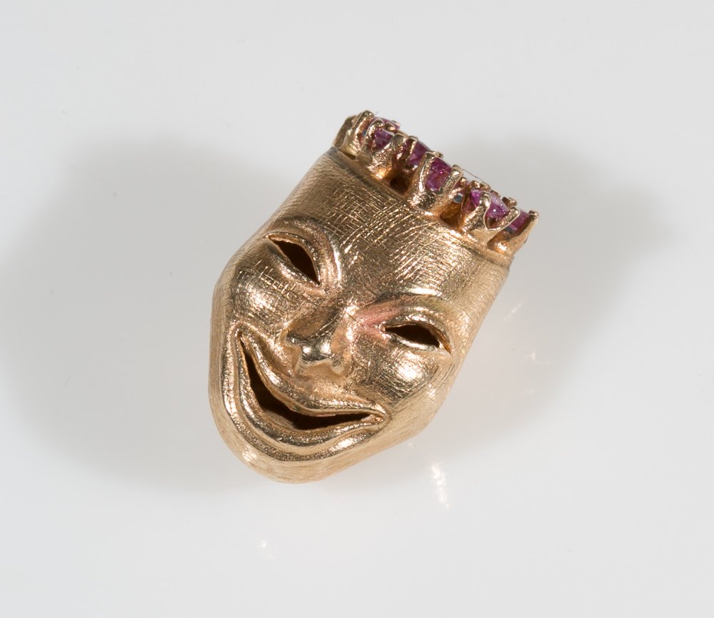 Gold Drama Charm / Pendent: (1) 14K yellow gold. Two sided drama face with semi precious blue and red stone (missing 2 stones). Total weight 9.9 grams.