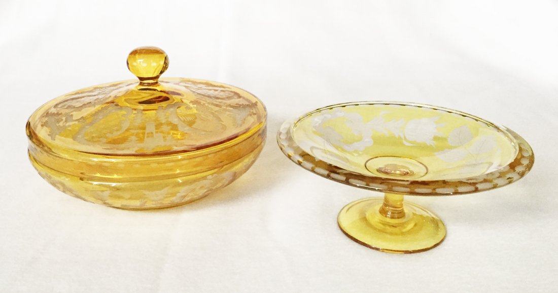 (2pcs) Bohemian Amber Glass Covered Bowl and Compote: 19th Century, Including: (1) 2 1/2"h x 6 1/4"dia. Compote engraved with floral and leaf Bohemian design. (1) 4 1/2"h x 7 7/8"dia. Covered bowl both decorated with castle and doe scene.