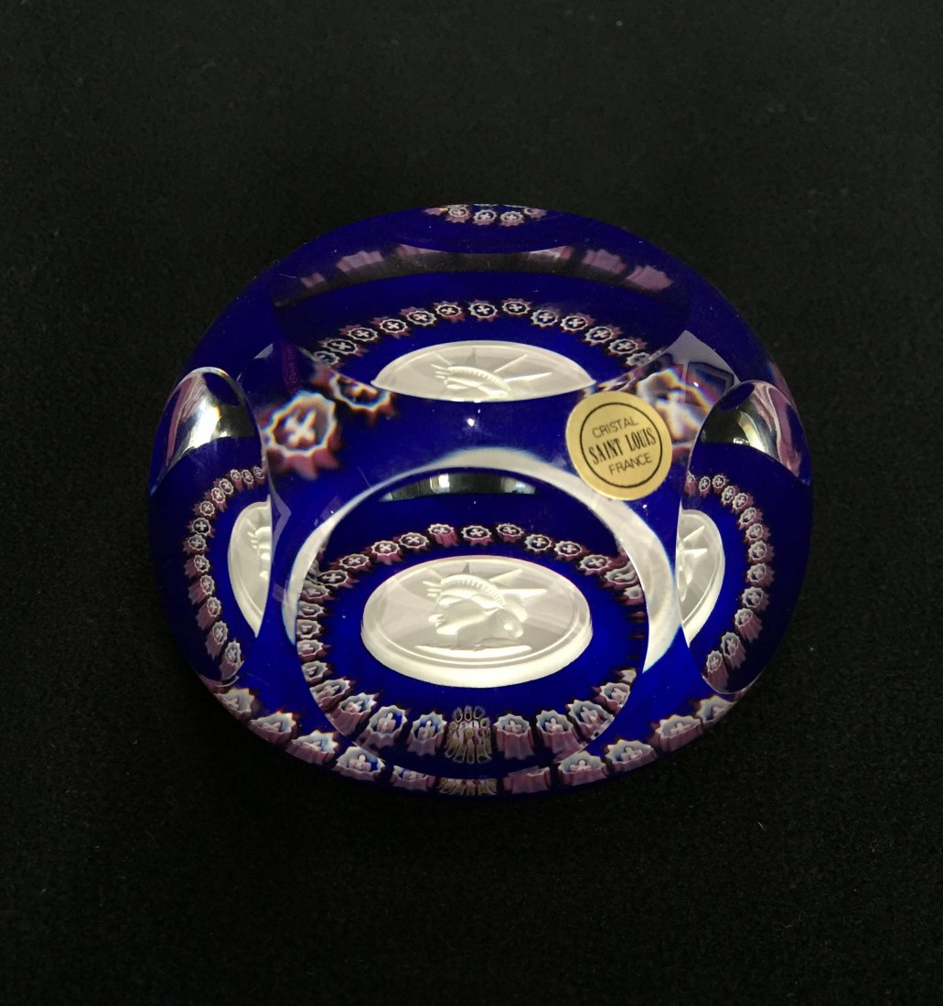 1986 Saint Louis Statue of Liberty Paperweight: (1) 2"h x 3"w, Saint Louis. blue and white with portrait of Statue of Liberty. With signature Saint Louis with date cane and sticker.