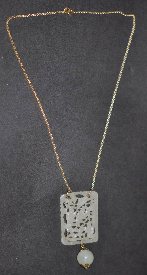 A Chinese White Nephrite Jade Necklace: The pedant is 1.5" long and 1.25" wide in 14KT gold chain., 19th. C.. The shipping cost is $25 plus insurance within the US (exincluding Alaska and Hawaii).