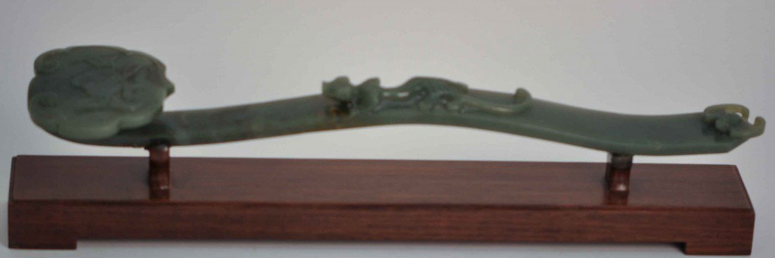 A Chinese Spinach Jade Scepter: 19th. C., 13.15" long and 2.75" wide on the head, 1.25" high. It's been repaired in the middle. The shipping cost is $58 plus insurance in the US (excluding Hawaii and Alaska).