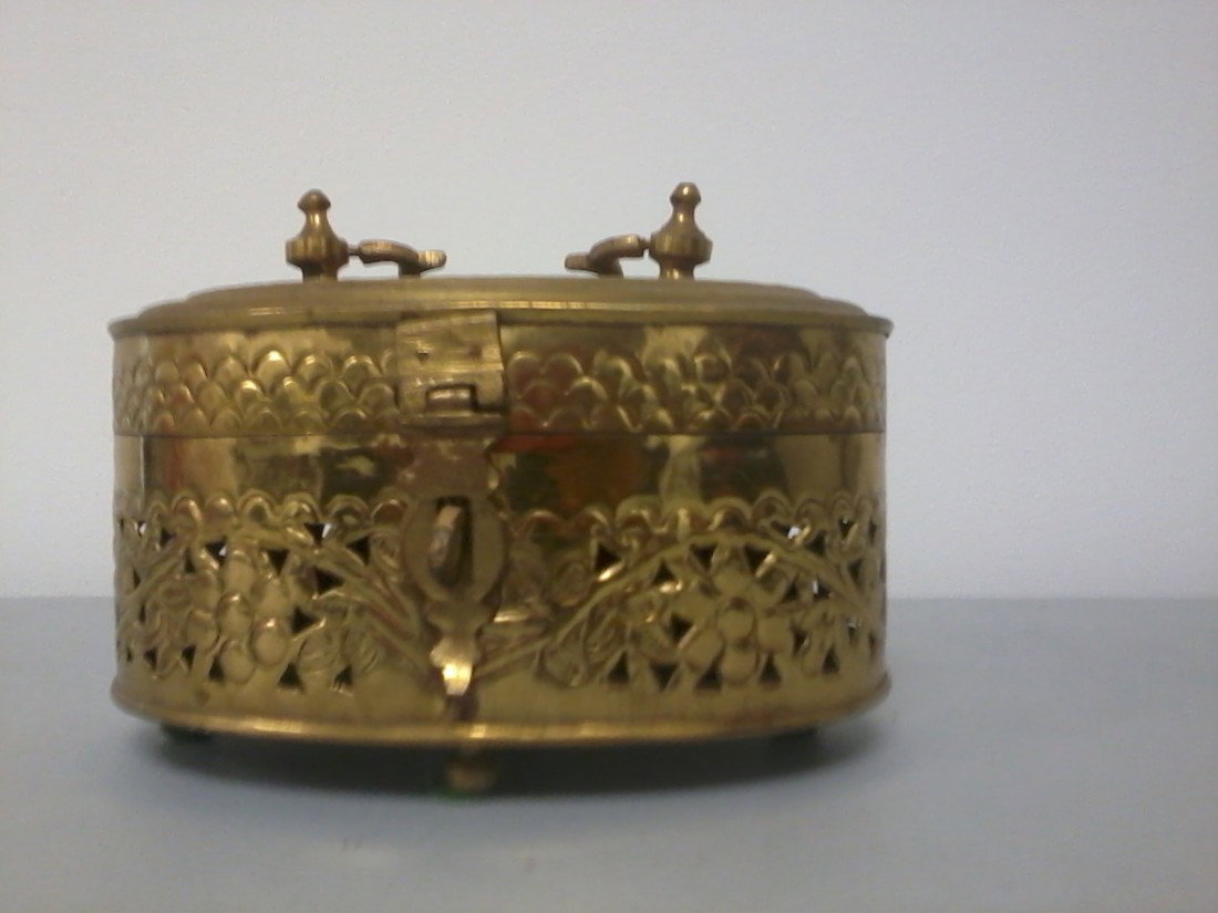 Oval shaped Brass inscence box treasure chest tri: Finely carved oval shaped brass inscence ,trinket chest box on four legs, puched carving on the box with a handle depicting floral and geometric design,H.6",W.7.5".