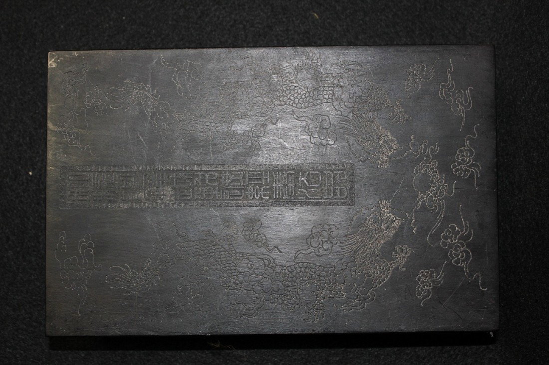 CHINESE BOOK OF CARVED JADE PLATES: CHINESE,CHINESE BOOK OF CARVED JADE PLATES,A HARD WOOD COVERD BOOK,FINELY CARVED TO DEPICT DRAGONS ON BOTH BINDINGS.SEAL MARK OF QIANLONG OF QING DYNASTY CARVED ON LOWER LEFT ON FRONT,THE REVERSE WITH