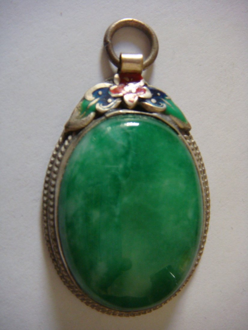 Emerald Green Jade Pendant with Silver Frame: Chinese carved pendant of emerald green jade; mounted on silver frame with subtle blue and red paint on jade carved prunus blossom, dimension: L5.0cm x W2.6cm x T1.0cmcm, 28grams.