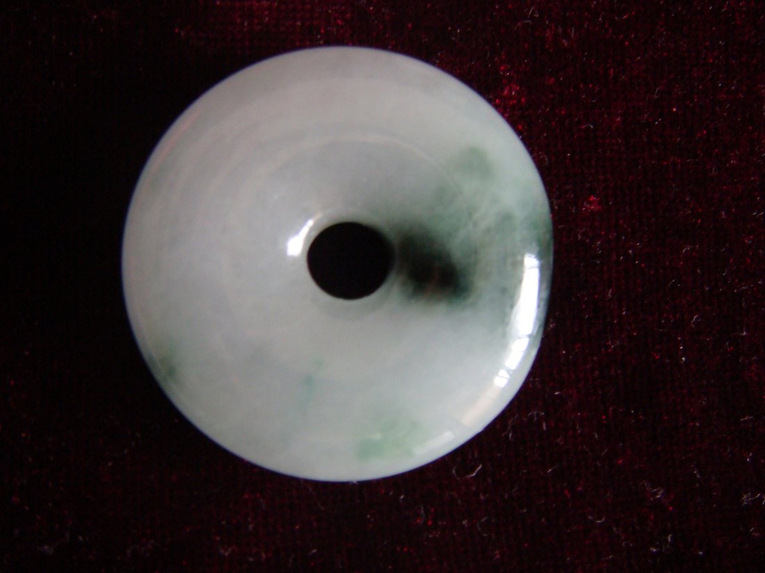 Chinese Carved Harmony Good Luck Bi-Disk of Jadeite: A fine Chinese carved good luck bi-disk of jadeite, a piece of fine jadeite of white tone mottled with a beautiful oil green, finely carved as a bi-disk, in Chinese, featuring a harmony and good luck.