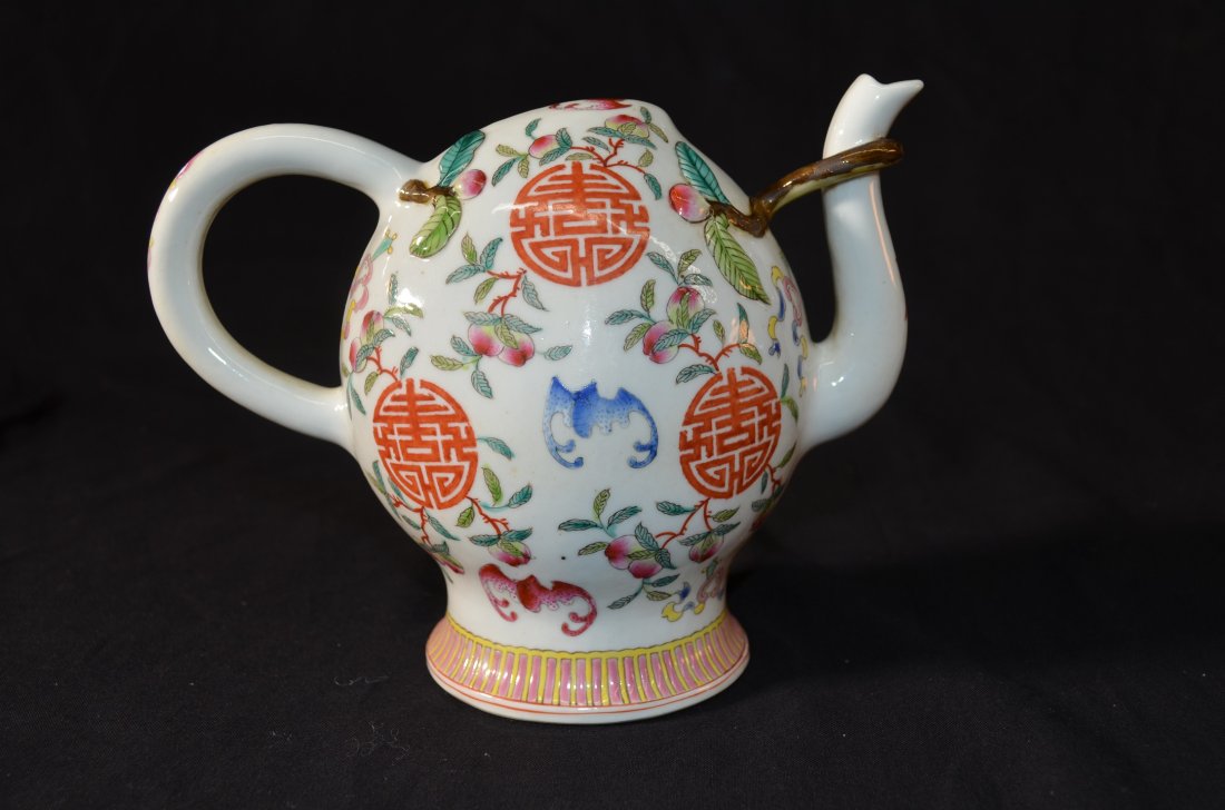 Chinese teapot: A Chinese Famille Rose Peach-Shaped Tea Pot 19th Century A teapot that has many various colored bats flying around peaches and a repeated Chinese character ,6"X7"