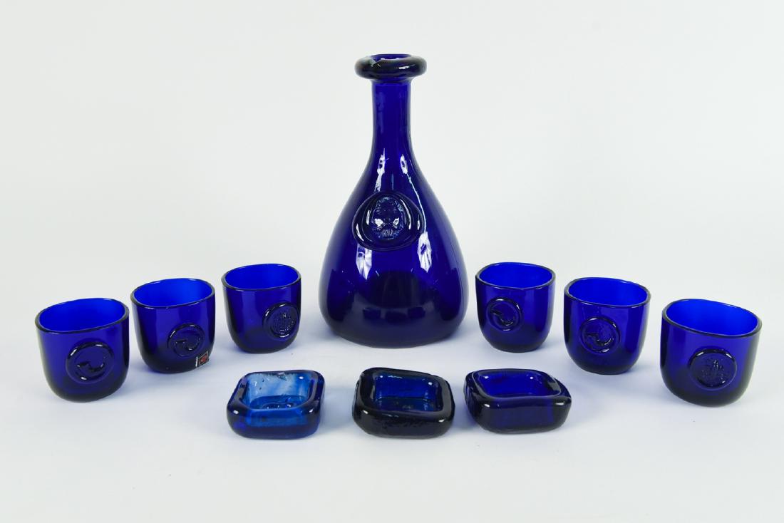 GROUP OF HOLMEGAARD COBALT GLASS: Includes decanter, 6 small cups, and 3 square objects. Dimensions: (Decanter) H 9" Condition: Decanter is missing stopper. X078