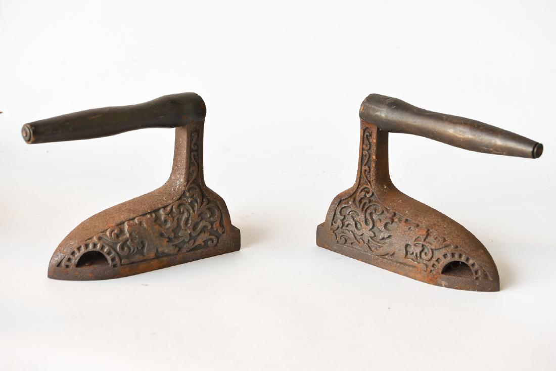 (2) ANTIQUE IRONS: Iron molded designs with wood handle Dimensions: H7" x W 3.75" x D 8", H7" W 3.75" x D9.5" Condition: No issues to note.