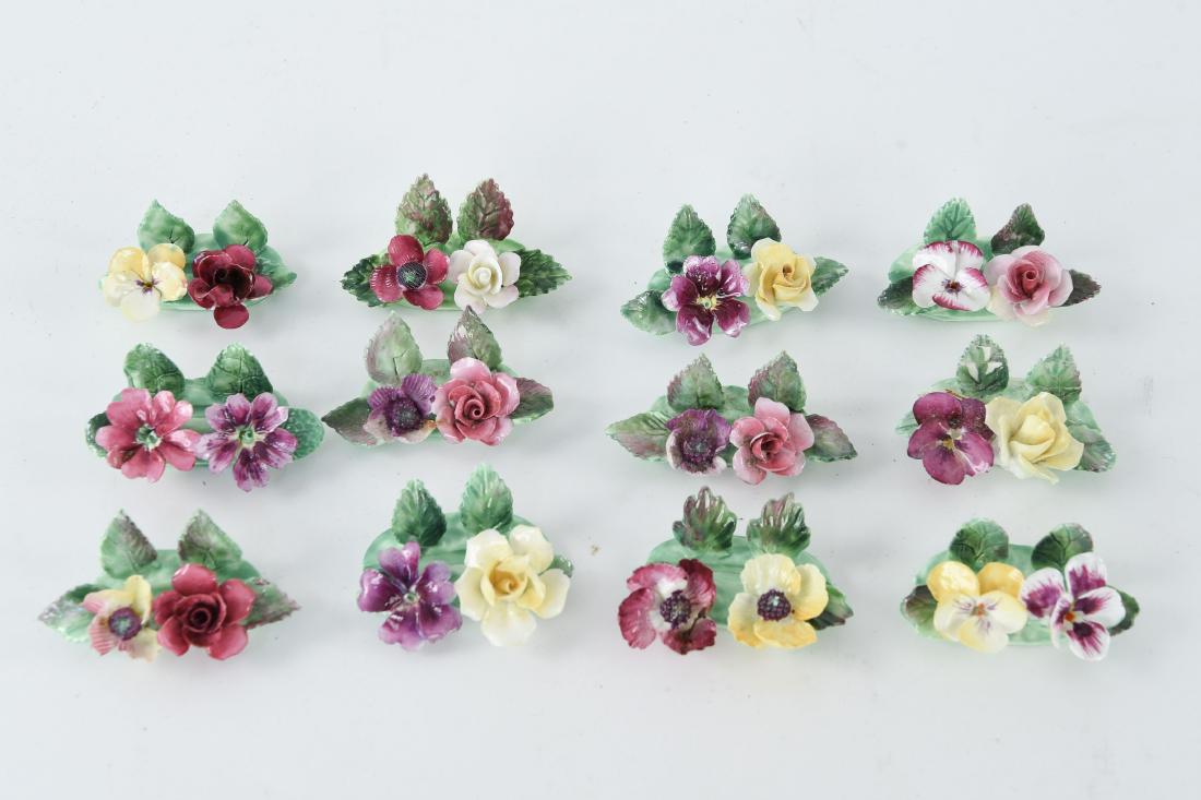 CROWN STAFFORDSHIRE PORCELAIN PLACE SETTINGS: (12) floral motif place settings. Marked underneath: Fine Bone China, Crown Staffordshire, Est. 1801, Made in England. Dimensions: (Each) H 1" x W 2.5" x D 1.25" Condition: Few flea bites to edges of