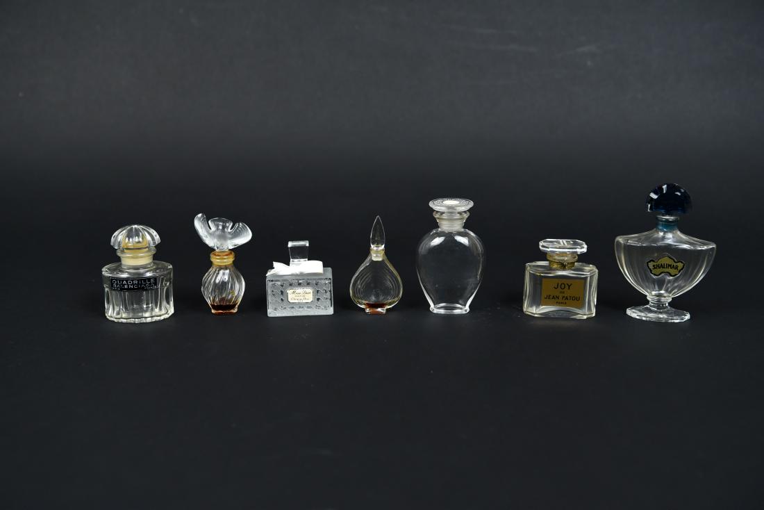 PERFUME BOTTLE GROUPING: (7) pieces. Including Balenciaga, Christian Dior, etc. Dimensions: (Largest) H 4" x W 2.75" x D 1" Condition: Varying degrees of wear. Showing signs of use.