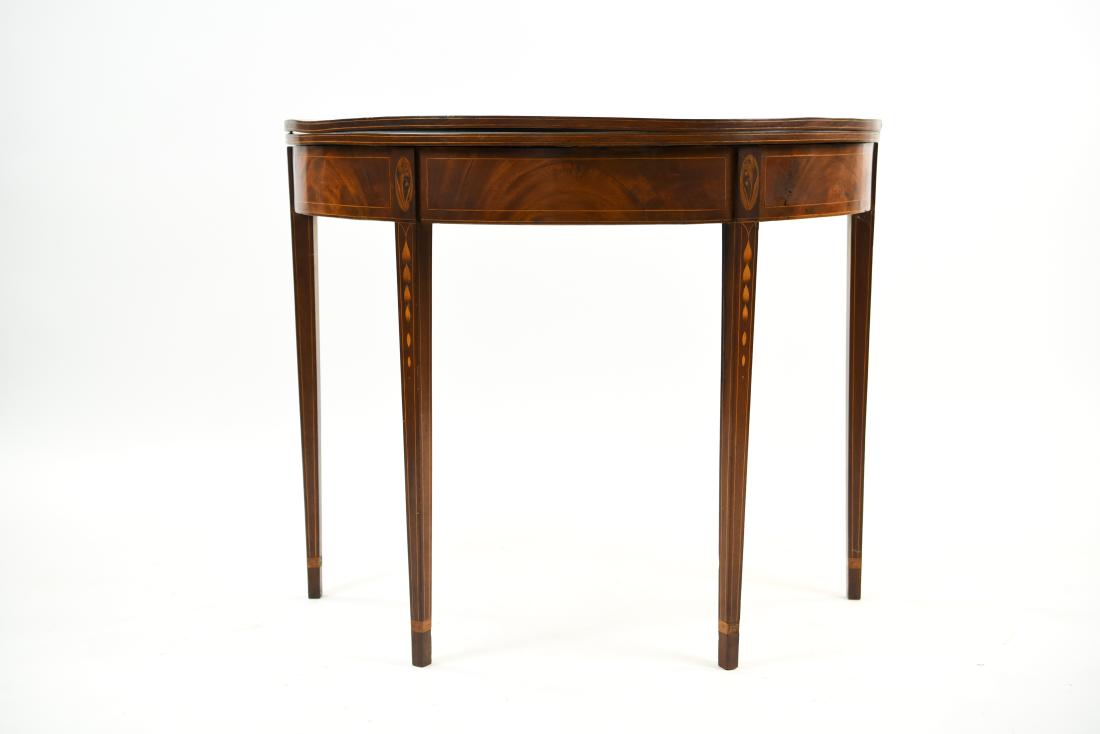 INLAID DROP LEAF DEMI LUNE TABLE: Dimensions: (Circle) H 29" x Dia. 35.5" Condition: Sun fading to wood. Finish wear. Surface warped. Few small losses to inlay. Wear consistent with age and use.