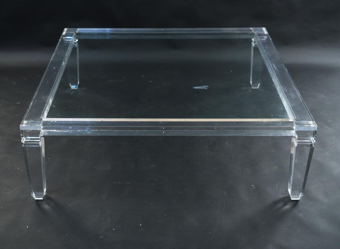 LUCITE AND GLASS COFFEE TABLE: Dimensions: H 16" x W 49" x D 49" Condition: Some light scratches and scuffs. Areas with tape residue. Blemish to the surface.