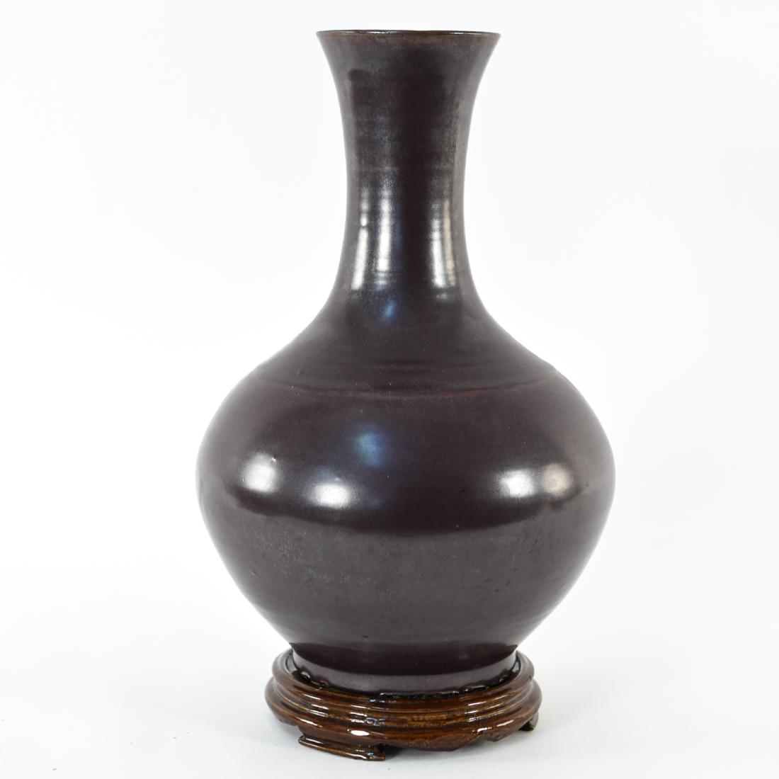 CHINESE DARK BROWN PORCELAIN VASE: Dimensions: H 15" x D 9" Condition: Hole drilled in bottom. Couple nicks to wooden base glaze.