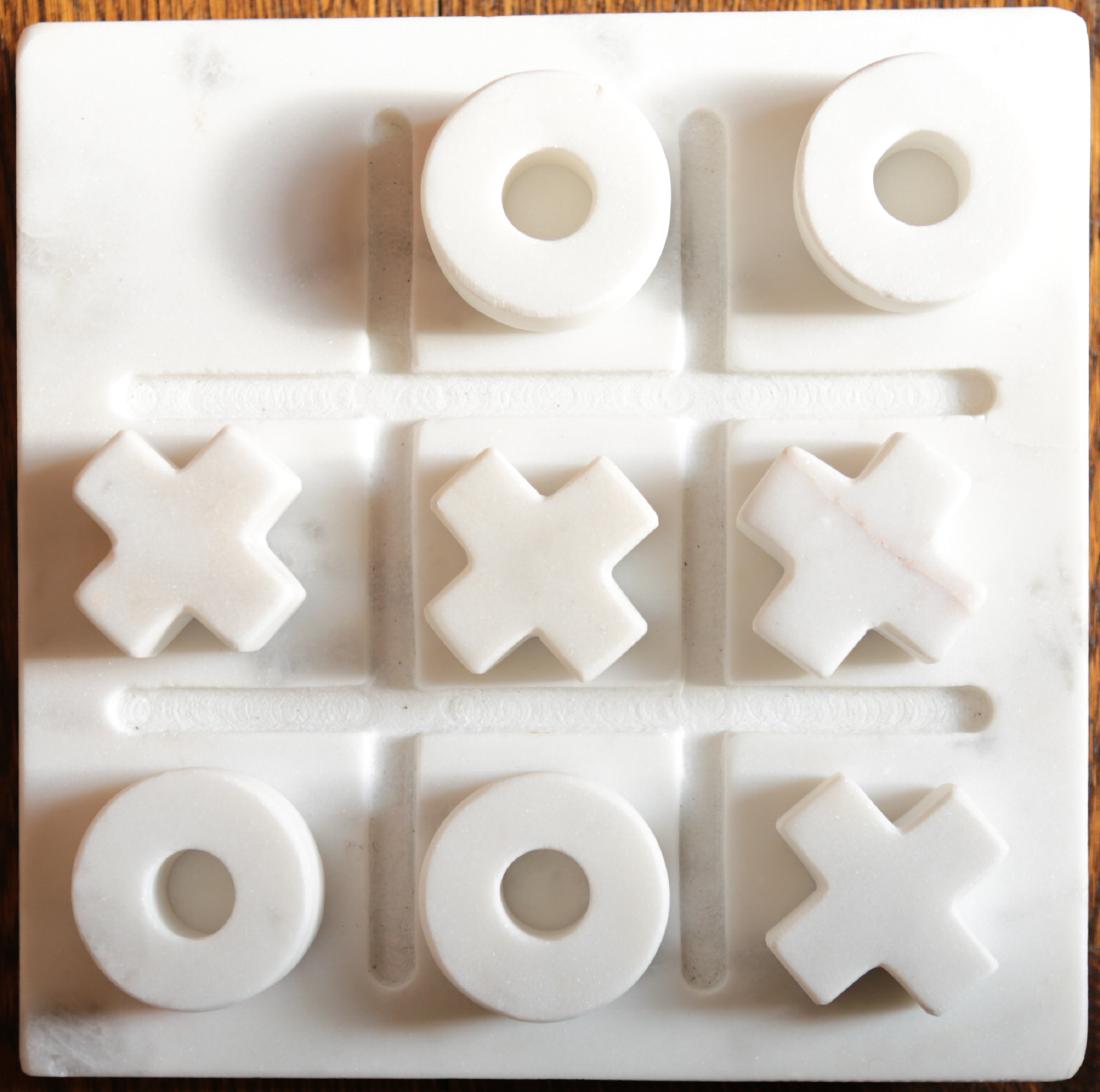 MODERN ITALIAN MARBLE TIC-TAC-TOE SET: Beveled and grooved marble base with four x’s and four o’s of carved marble. Dimensions: (Base) H 8” x W 8” Condition: Chips to two corners of base.