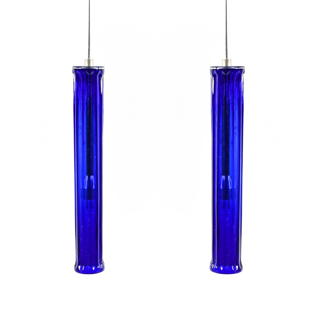 PAIR OF BLUE FLUTED GLASS PILLAR PENDANTS: Dimensions: H 10.5" x Dia. 1.5" Condition: May need to be rewired. Few minor flea bites to rims. Rust.