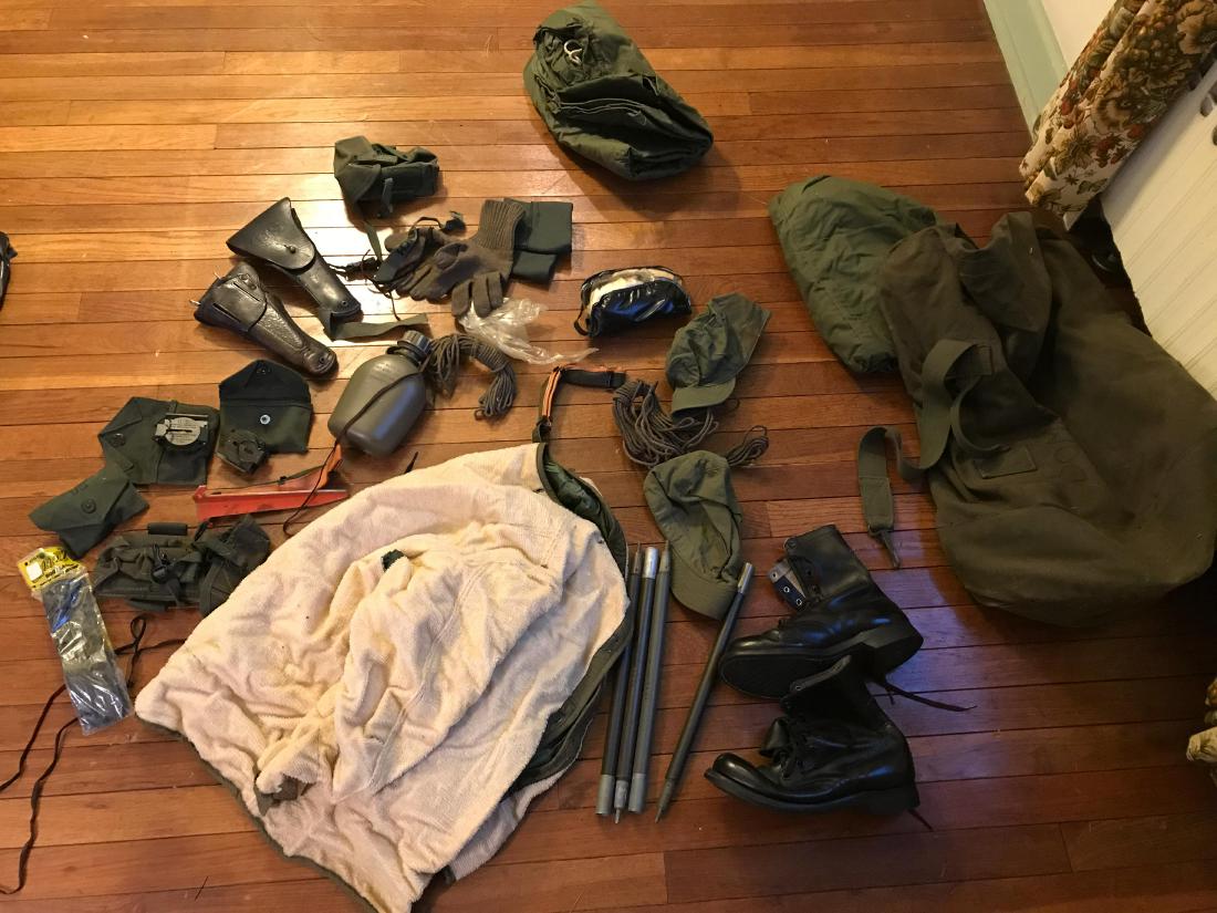 VINTAGE US ARMY GEAR: Including boots, holsters, a canteen, and more. Dimensions: H 21" x D 15" (Packed in bag) Condition: Showing light wear consistent with age and use.