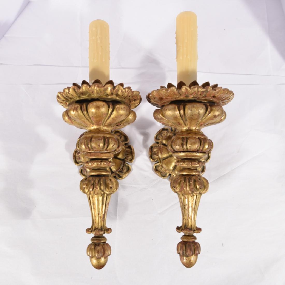 PAIR OF CARVED WOOD TORCHIERE SCONCES: Vintage, carved with antiqued gold finish. Measurements: H 18.5" x W 7" x D 9.75" Condition: Rewired, some loss to finish.