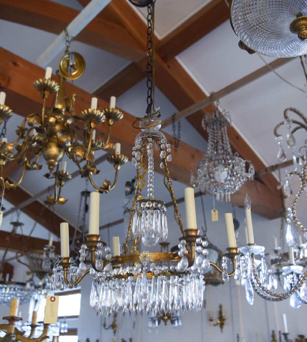 VINTAGE BRASS & CRYSTAL CHANDELIER: 6-light. Antique finished brass, with drop crystals. Dimensions: H 23" x Dia. 21" Condition: Looks to be complete.