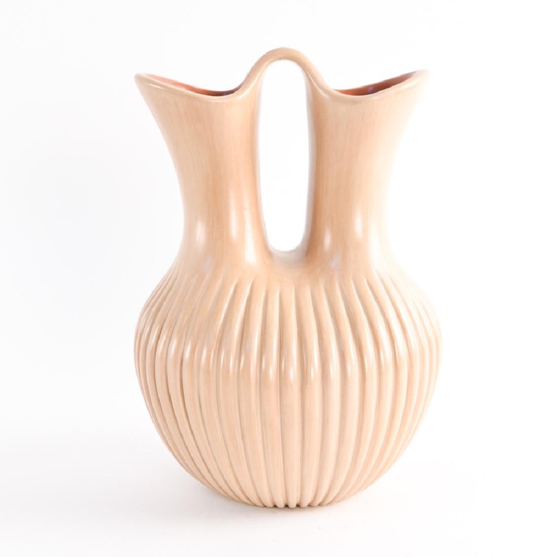 LAURA GAUCHUPIN (B. LATE 1950S): Jemez Pueblo beige pottery wedding vase. With carved melon ribs. Signed on base. Dimensions: H 9" x Dia. 7" Condition: No issues to note. Provenance: From a Greenwich, CT estate.