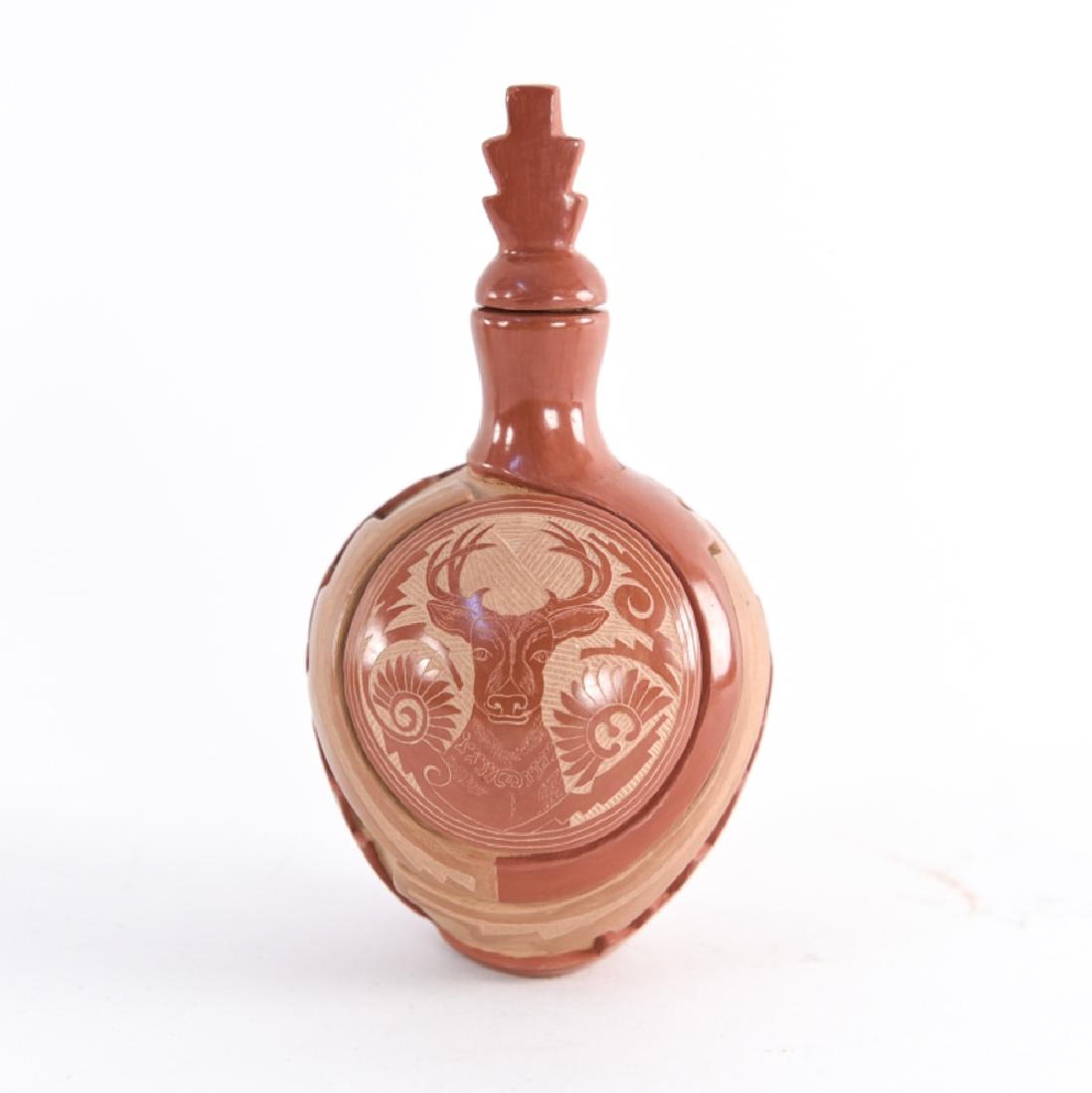 GRACE MEDICINE FLOWER (B. 1938): Santa Clara Pueblo scrafitto decorated red sienna pottery flacon with stopper. Signed on base. Dimensions: (With stopper) H 6.5" x Dia. 3.5" Condition: Cracking where neck is attached to body. Provena