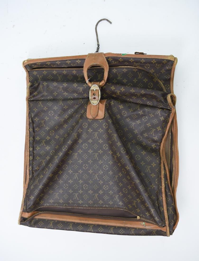 VINTAGE LOUIS VUITTON GARMENT BAG: Dimensions: H 25" x W 23" x D 4" Condition: Corner wear. One zipper broken and torn. Distress to metal. Old luggage tags. Generally worn, with losses.