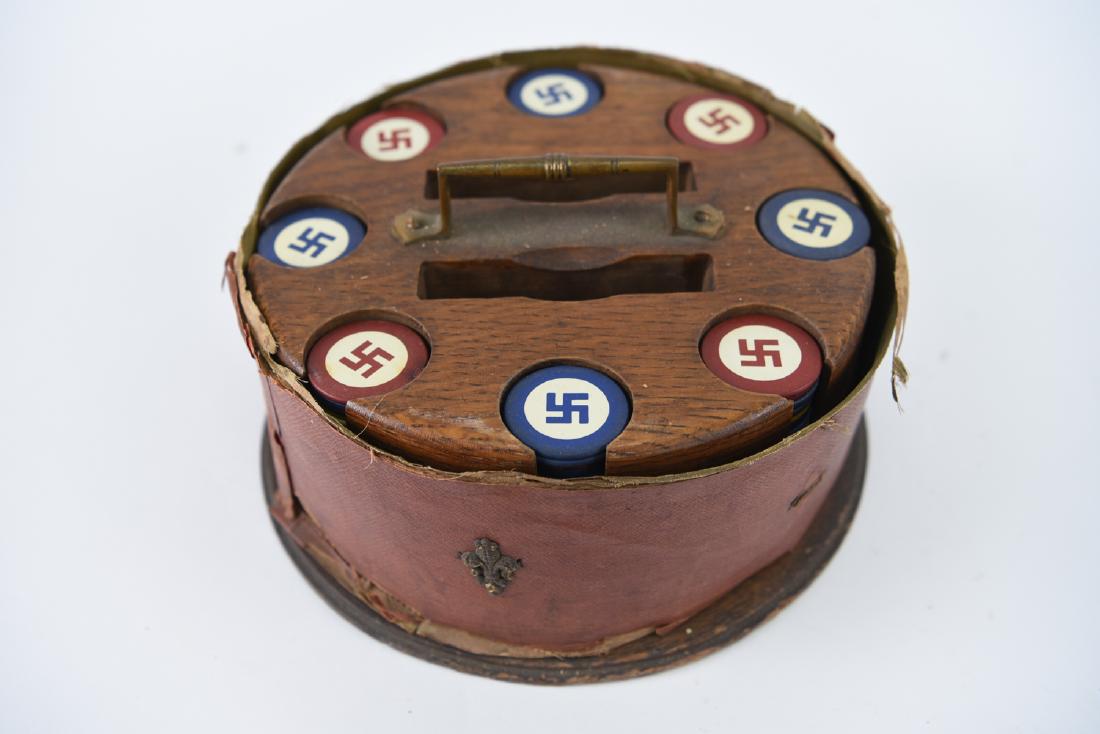 C. 1910 POKER CHIPS W/ GOOD LUCK SYMBOL: 19th century chip holder. Oak rack, brass handle. Eight stacks of chips and holders for two sets of cards, in a composition covered casing. Dimensions: (Case) H 5" x Dia. 9" Condition: Casing coming a
