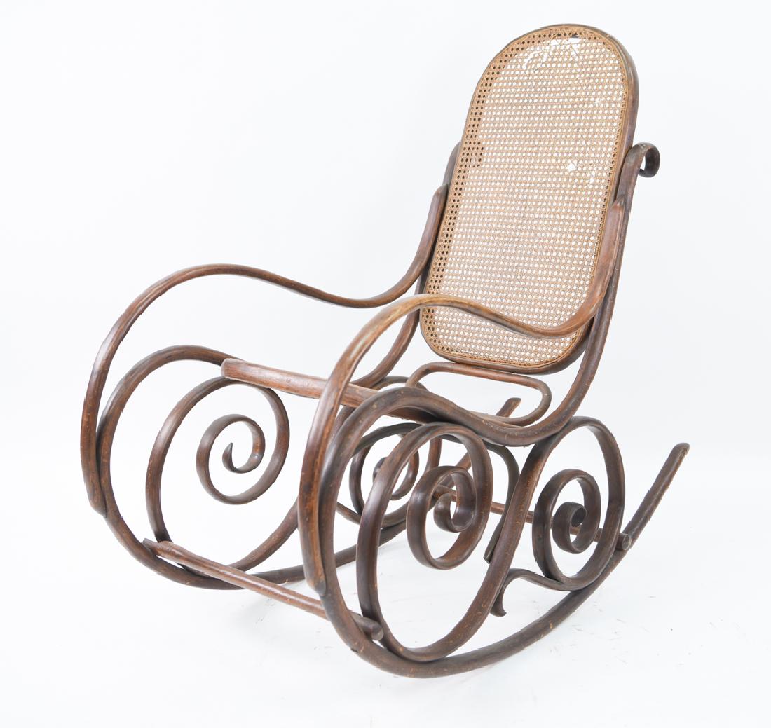 THONET STYLE ROCKING CHAIR: Bentwood frame with caned seat and back. Dimensions: H 43" x W 22.5" x D 46" x SH 17" Condition: Some surface wear. Breaks in back caning.