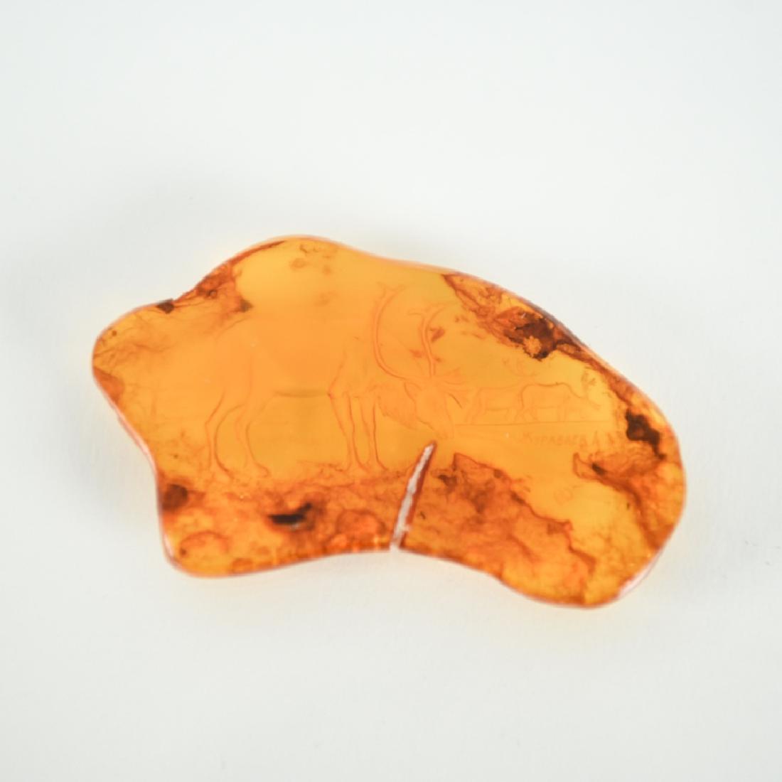 INTAGLIO CARVED AMBER ELK SIGNED: Finely reverse carved scene of elk. Signed. Dimensions: L 2.5" x W 1.5" Weight: 7 grams Condition: no issues to note.