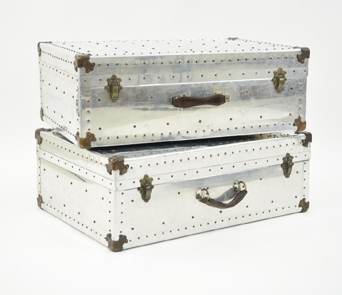 PAIR OF STUDDED ALUMINUM CLAD SUITCASES: A matched pair with brass hardware and brass rivets. Dimensions: H 23" x W 32.5" x D 11.5" Condition: Surface scuffs and scratches consistent with age and use. Sturdy handles and working hardware. Som