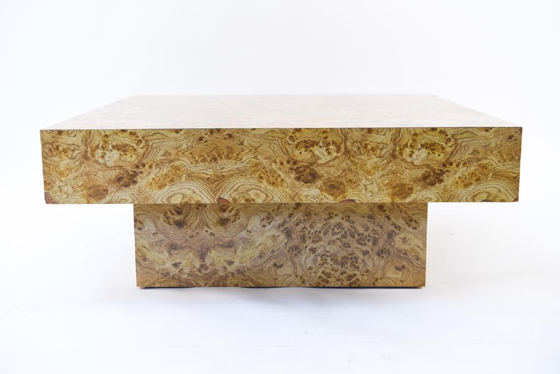 MILO BAUGHMAN STYLE BURLWOOD FINISH COFFEE TABLE: Laminate veneer, 1960s, in the style of Milo Baughman. Dimensions: H 15" x W 38" x D 38" Condition: Corners chipped. Surface with some light scratches.