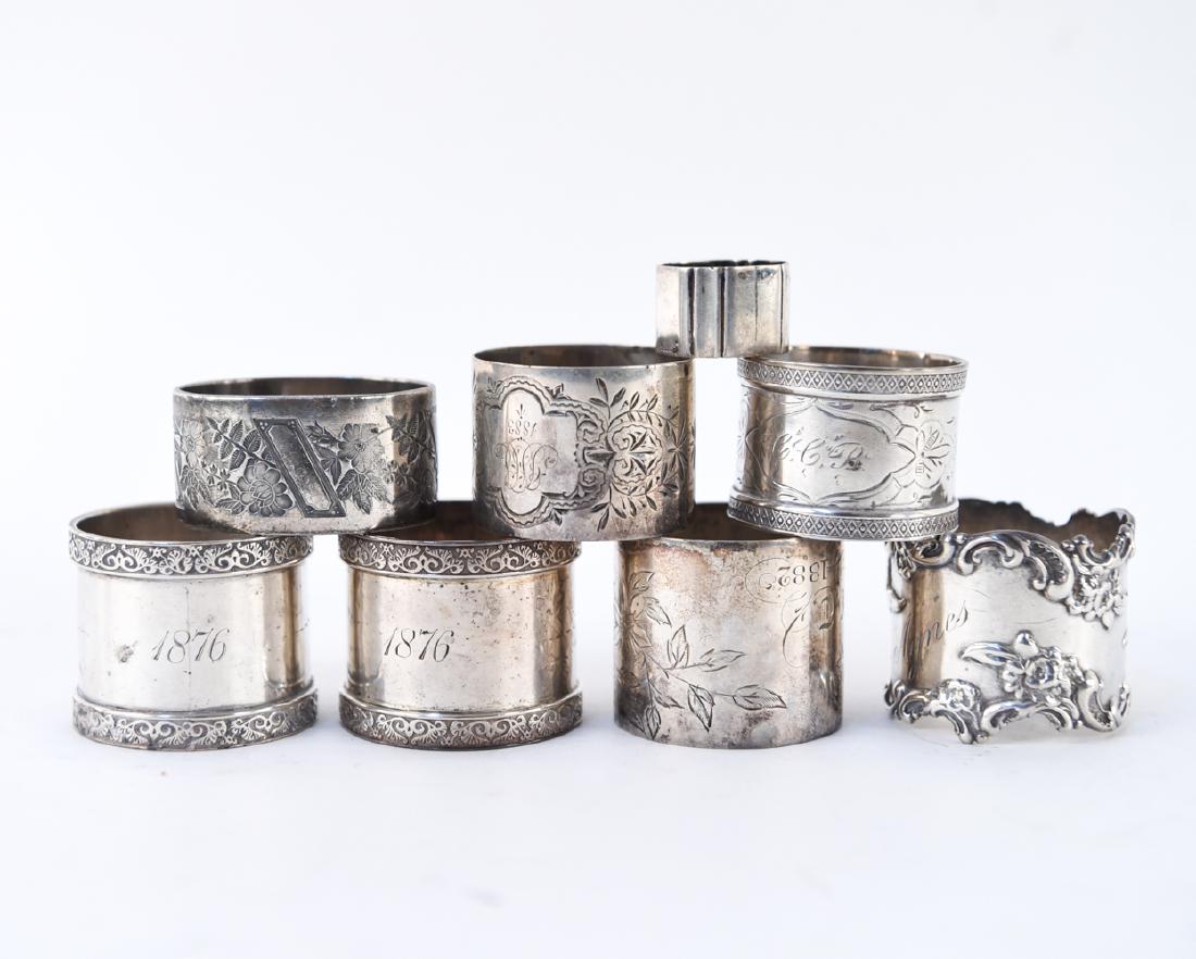 GROUPING OF SILVER NAPKIN RINGS INCL. STERLING: Some marked sterling. (8) pieces. Dimensions: (Largest) H 1.5" x Dia. 1.75" Weight: (Overall total) 7.535 ozt Condition: Some denting, tarnish. Light wear consistent with age and use.