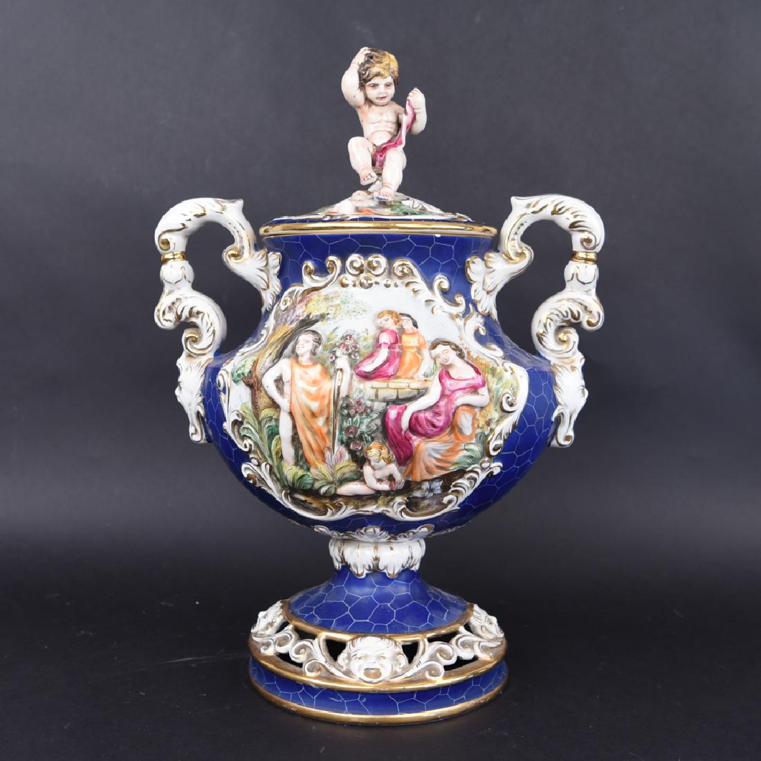 KERAMOS R. CAPODIMONTE LIDDED URN: Marked under base. Dimensions: H 22" x W 15" x D 11" Condition: Showing handling wear including losses to file areas. Hairline fractures visible under base. Few small chips to rim of urn, Small chip t