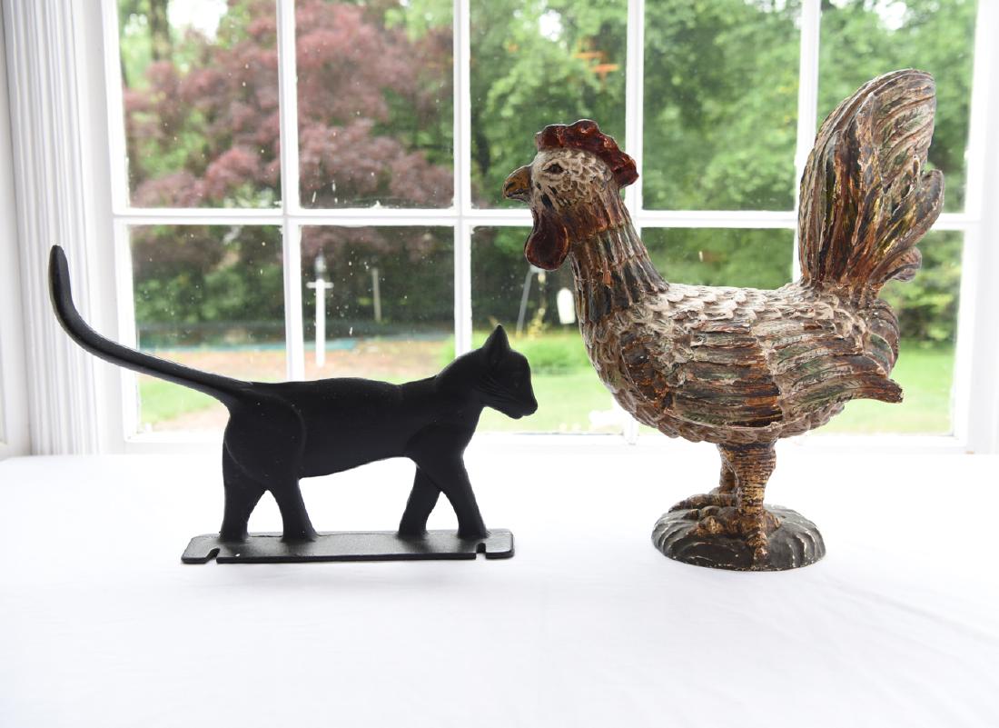 DECORATIVE CHICKEN & CAT: Carved and painted wood chicken, cast metal boot scraper. Dimensions: (Chicken) H 17" x W 15" x D 9" Condition: Chips to paint finish of chicken.