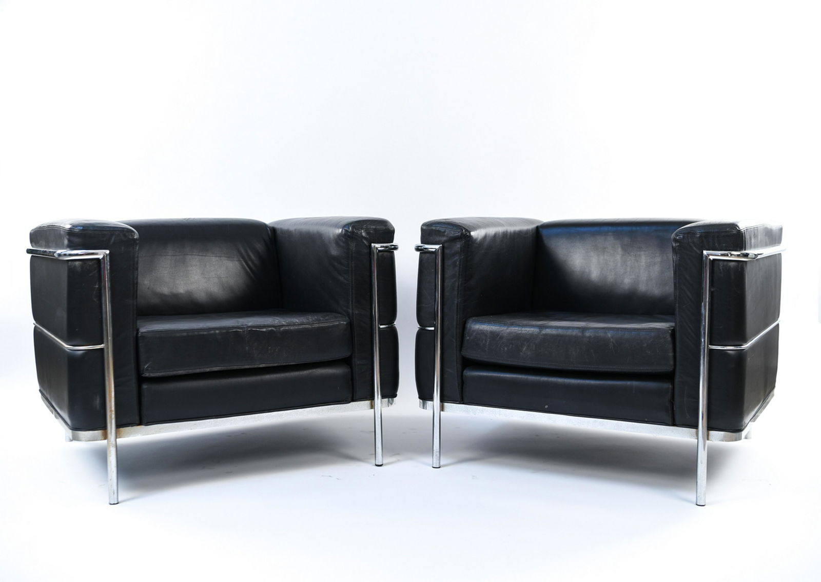 PAIR OF LOUNGE CHAIRS BY JACK CARTWRIGHT: Dimensions: H 27.5" x W 35" x D 29" x SH 16" Condition: Minor scratches and rubbing to leather, patina to base.