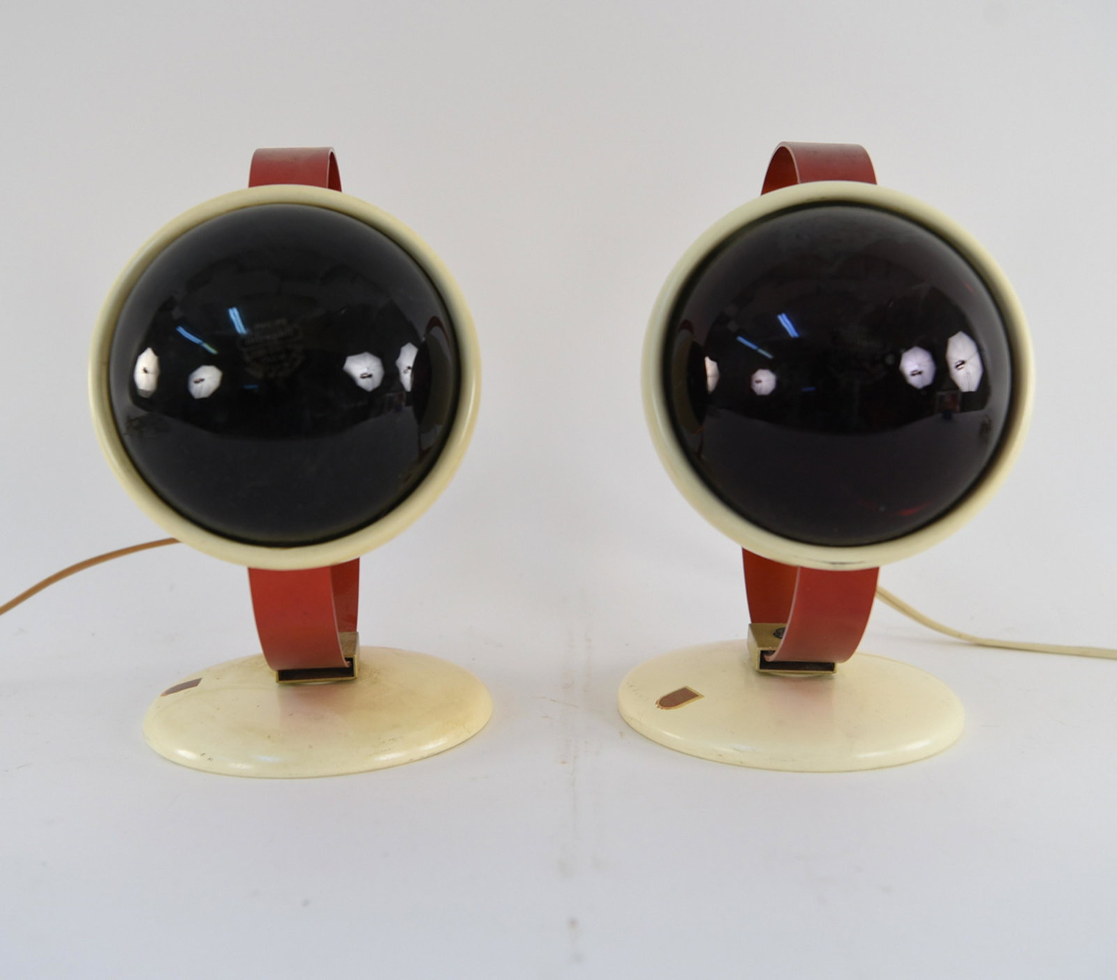 (2) CHARLOTTE PERRIAND FOR PHILIPS INFRAPHIL LAMPS: Designed 1952. Enameled metal and aluminum. Dimensions: H 9.5" x W 6.5" x D 10" Condition: Some minor scratching to the finish here and there. Wear consistent with age and use.