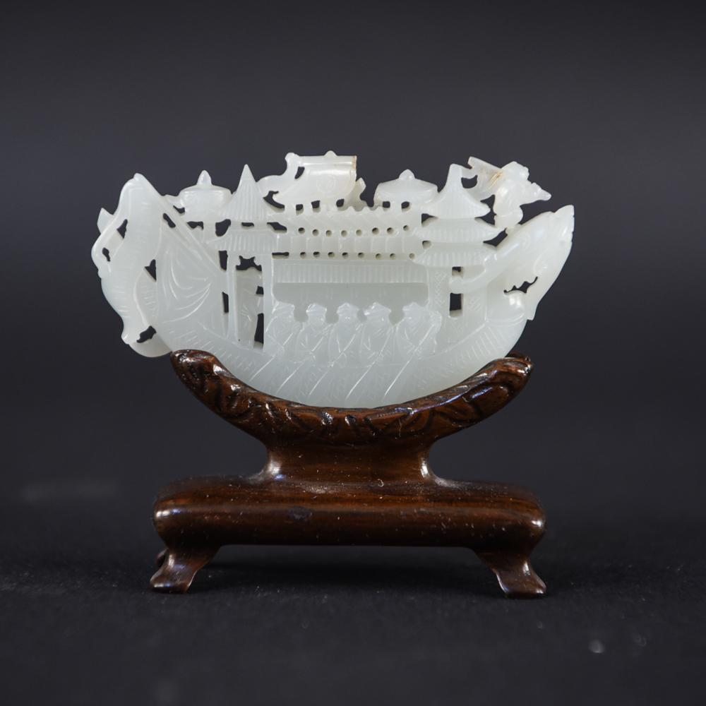 CHINESE HARSTONE BOAT CARVING: With wooden stand. Figures rowing a boat. Dimensions: (On stand) H 2.75" x W 3" x D 1" Condition: Small loss to upper edge. Loss to one foot of stand.