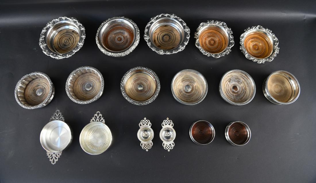 GROUPING OF SILVER PLATE WINE COASTERS ETC.: Various pieces, mainly wine bottle coasters. Dimensions: (Largest) H 2.75" x Dia. 7.25" Condition: Some signs of age and use.