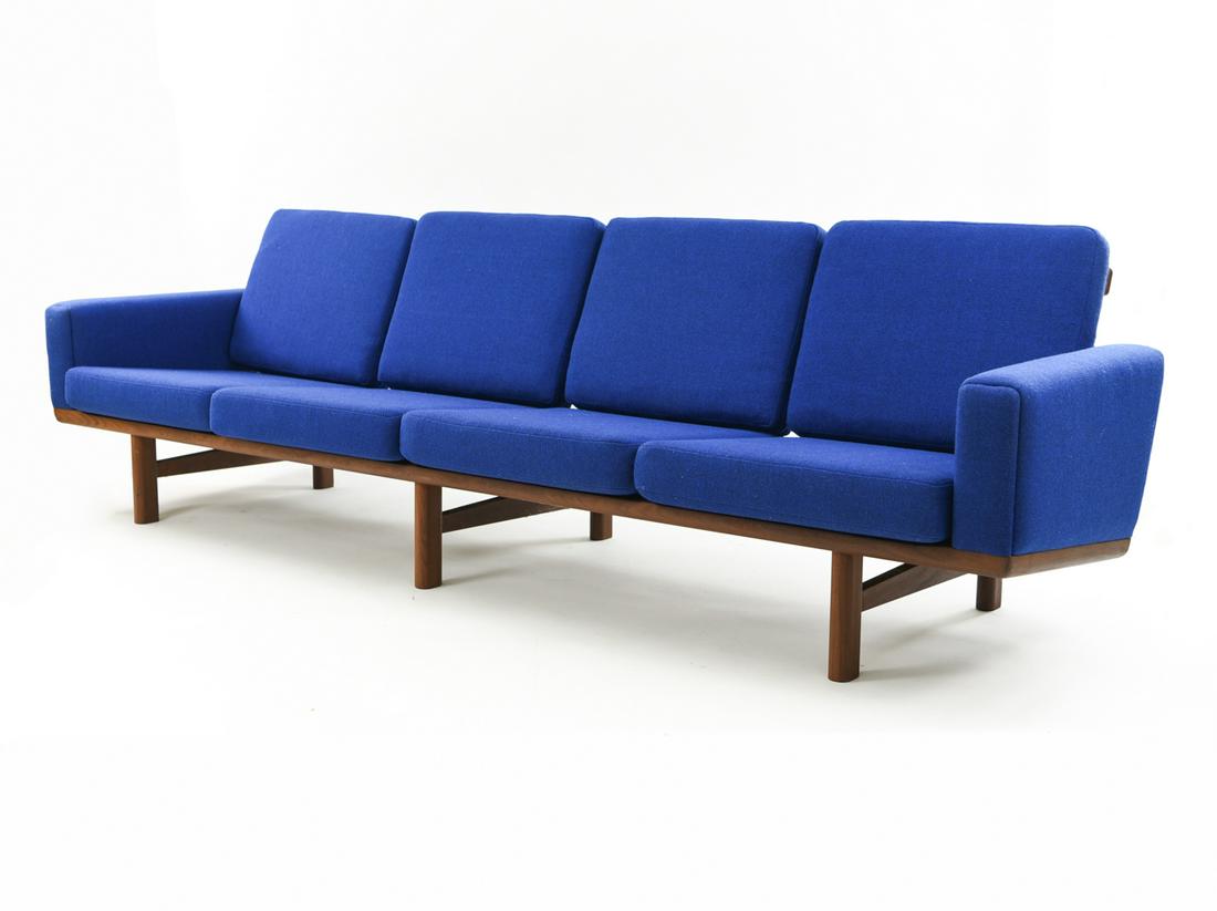 HANS WEGNER FOUR SEATER SOFA C. 1960: Hans J. Wegner (1914-2007), four-seater sofa, frame in solid teak, cushions upholstered in blue furniture fabric. model GE-236/4. 1960s Dimensions: H 30" x W 106" x D 31" x SH 15" Condition: Showing l