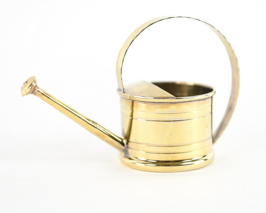 CARTIER STERLING SILVER WATERING CAN: Hallmarked, with gold wash. Dimensions: H 3.5" x W 5" Condition: dent to bottom, some wear at edges.