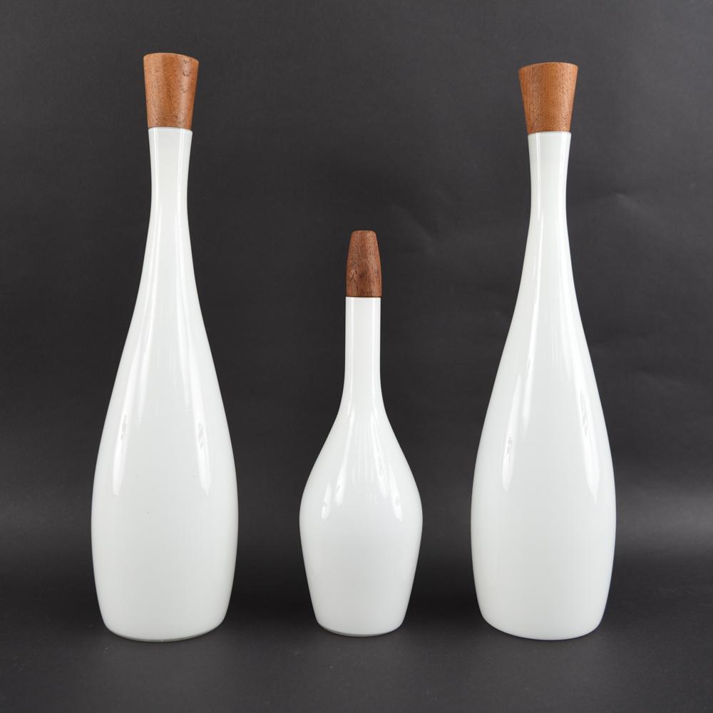 (3) KASTRUP WHITE CASED DECANTER BOTTLES: with Raymor paper label to the two larger ones. Dimensions: Largest: H 19" x Dia: 5" Condition: one small chip to rim.