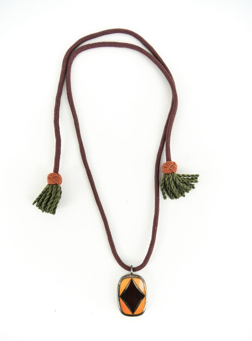 GEORG JENSEN ENAMEL PENDANT NECKLACE: An enamel and sterling silver pendant on original braided cord. With Georg Jensen hallmark to back. Dimensions: Pendant: H 1.5" x W 1" Cord: L 33" Condition: some tarnishing, no losses to enamel, very
