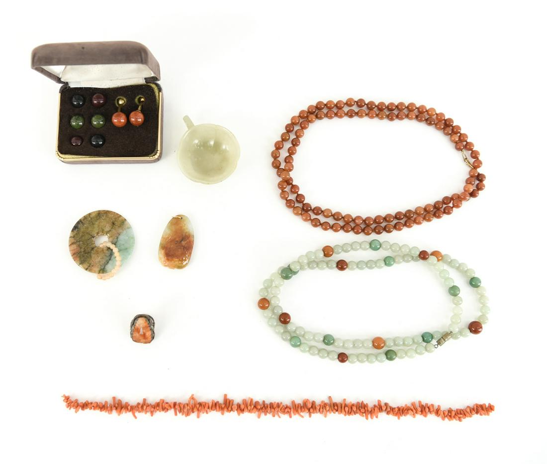 JADE AND CORAL GROUPING: Including jade cup, cufflinks with inter changable stones, a jade/russet bi, a carved jade pendant, Art Nouveau carved carnelian and sterling ring, branch coral necklace fragment, Jade and carnelian n