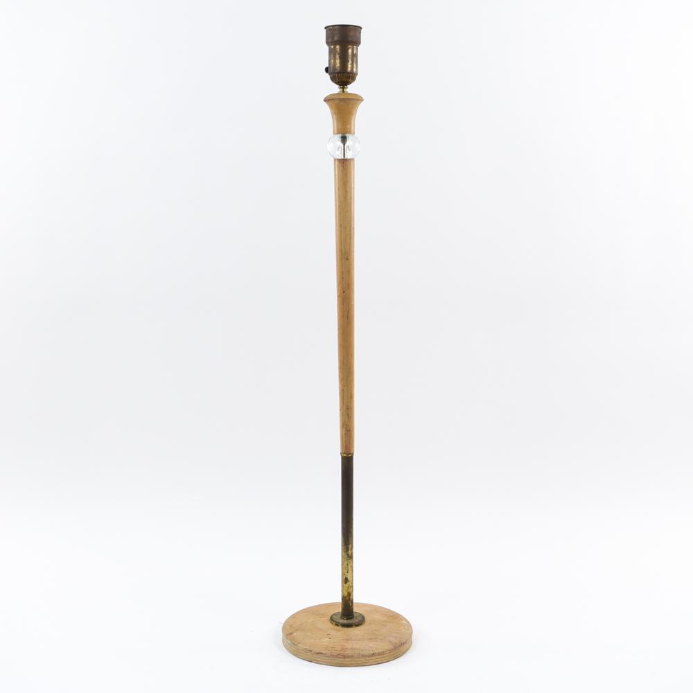 MANNER OF RUSSEL WRIGHT FLOOR LAMP: Dimensions: H 55.5" x Dia. 12" Condition: In need of rewiring. Crack to wood. Pitting and tarnish to metal. Wear and marks to wood.