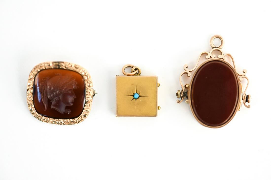 ANTIQUE JEWELRY GROUPING INCL LOCKETS: Including a 14k gold and carnelian locket fob, a intaglio carved carnelian and 10k gold pin and a 10k and turquoise locket. Dimensions: Largest: H 1.5" x W 1.25" Total Weight: 14.5 dwt Condition: show